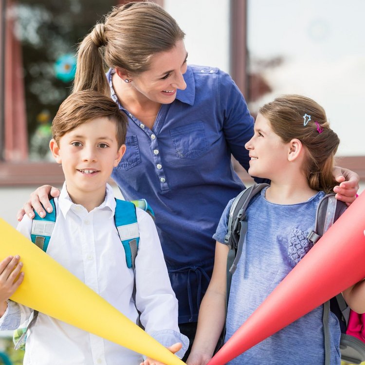 Celebrating school enrollment in Hamburg – children with school cones in front of the school building