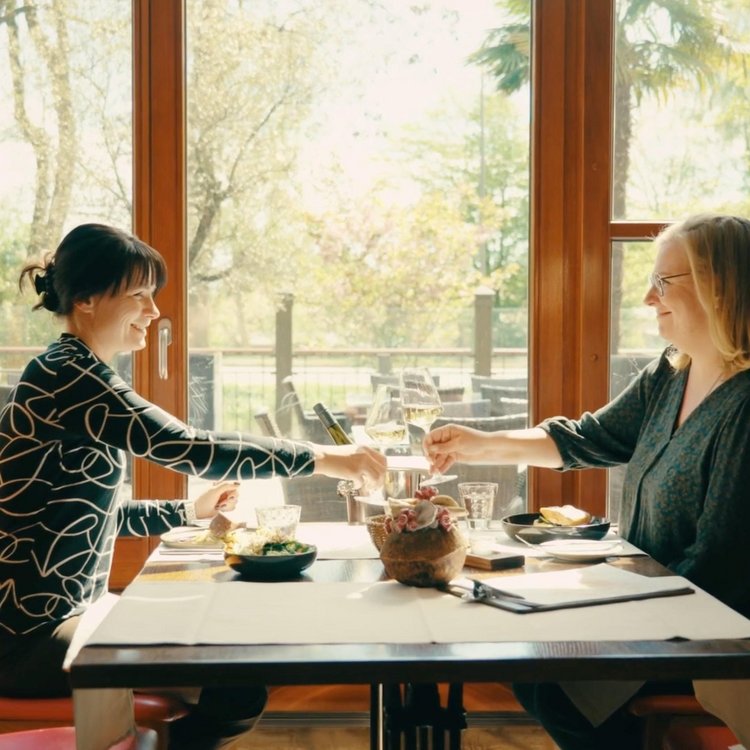 Zwei Damen stoßen vor dem Dinner mit Sekt an